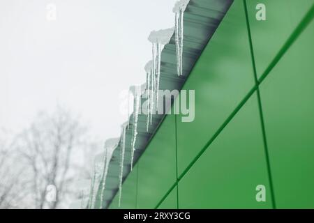 Ghiaccio sul tetto. Ghiaccio sull'edificio. Glassa della visiera. Scioglimento della neve. Icicle appeso alla visiera. Foto Stock