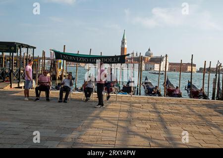 Venezia, Italia, 12 settembre 2023, i gondolieri aspettano i clienti alla fermata del servizio gondolieri Foto Stock