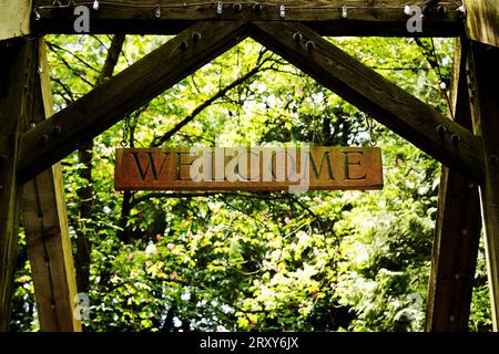 Cartello di benvenuto in legno sul cancello d'ingresso nel bosco Foto Stock