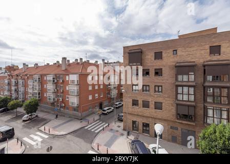 Facciate di un edificio residenziale ad un incrocio di strada con incroci di zebre dipinte costruite con mattoni marrone chiaro Foto Stock