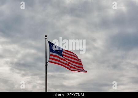 La bandiera americana sventolava orgogliosa e sventolava su uno sfondo spettacolare di nuvole Foto Stock