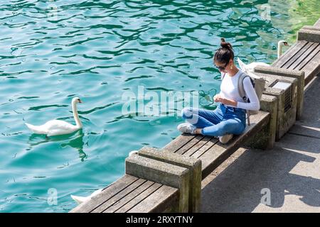 Giovane donna seduta sul molo, Quaianlagen , città di Zürich, Zürich, Svizzera Foto Stock