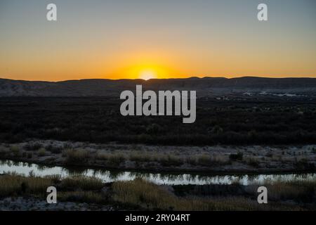 Il sole tramonta sotto l'orizzonte sopra lo stretto Rio grande a Big Bend Foto Stock