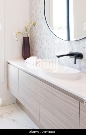 Vista a ritaglio del lavandino in ceramica bianca e del rubinetto nero nel bagno moderno. Idea di interior design. Concetto di relax con spa casalinga. Foto Stock