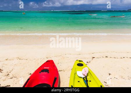 I colorati kayak di plastica si stendono su una spiaggia in una giornata di sole, alle Seychelles Foto Stock