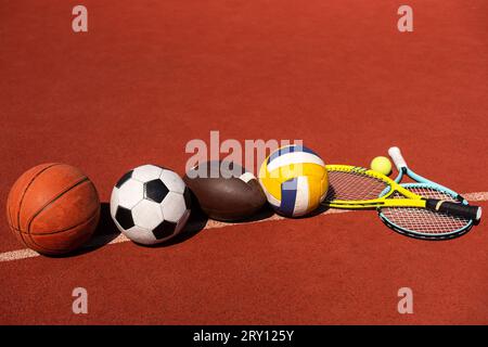 Set di attrezzature sportive, palle da calcio, pallacanestro e racchette da tennis Foto Stock