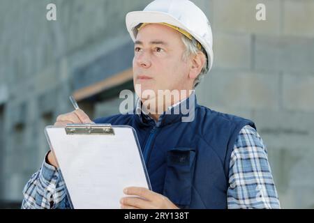 costruttore che prepara stima per miglioramento esterno domestico Foto Stock