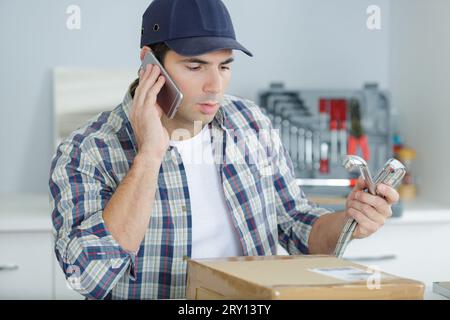 tecnico che esegue la lettura dei contatori utilizzando il telefono cellulare Foto Stock