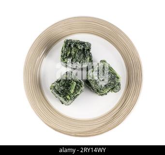 foglie di spinaci congelate in cubetti sulla piastra su sfondo trasparente Foto Stock