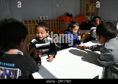 (230928) -- YUSHU, 28 settembre 2023 (Xinhua) -- Pusum Dongdrup (2nd L) gioca con altri bambini in un'aula di un asilo nella contea di Qumarleb della prefettura autonoma tibetana di Yushu, provincia del Qinghai della Cina nord-occidentale, 14 settembre 2023. La contea di Qumarleb si trova nella regione sorgente del fiume giallo, con un'altitudine media di oltre 4.500 metri. Qui i bambini conducono una vita nomade con le loro famiglie su ampie praterie lontano dai capoluogo di contea e dalle città. Attraverso anni di sforzi da parte del governo locale, l'istruzione prescolare gratuita è stata estesa alle aree di pascolo. Proprio intorno a casa loro, amico Foto Stock