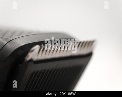 macro shot di primo piano dei denti del regolacapelli o della lama del rifinitore utilizzati per la rasatura su uno sfondo bianco Foto Stock