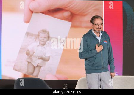 Eckart von Hirschhausen moderiert die Veranstaltung und zeigt ein Kinderfoto vom unbeschwerten Urlaub an der Ostsee, Dirk Rossmann und Ralf Hoppe präsentieren ihr neues Buch Der Club des Oktopus bei einem ganztägigen Event mit prominenten Gästen in der alten Maschinenhalle in Kappeln an der Schlei, es geht um Klimawandel, Die Verschmutzung der Meere und die Folgen für Mensch und Umwelt, Schleswig-Holstein 27.9.2023 *** Eckart von Hirschhausen modera l'evento e mostra una foto di bambini di una vacanza spensierata nel Mar Baltico, Dirk Rossmann e Ralf Hoppe presentano il loro nuovo libro The Club of Th Foto Stock