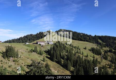 Wallberg, Bayern, Deutschland 27. Settembre 2023: Hier der Blick auf das alte Wallberghaus, Berghotel, darüber die Heilig Kreuz Kapelle und rechts davon die Bergstation der Wallbergbahn, sowie dem Gipfel des Wallberg, wandern, spazieren *** Wallberg, Baviera, Germania 27 settembre 2023 qui la vista della Vecchia Vallberghaus, albergo di montagna, sopra di essa la Cappella della Santa Croce e a destra la stazione a monte della Wallbergbahn, così come la cima del Wallberg, escursioni, passeggiate Foto Stock