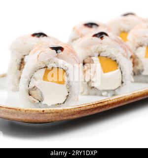 Piatti asiatici - sushi, PANINI KYOTO con riso, formaggio spalmabile, nori, anguilla, mango, gamberetti, salsa unaghi su sfondo bianco. Foto Stock
