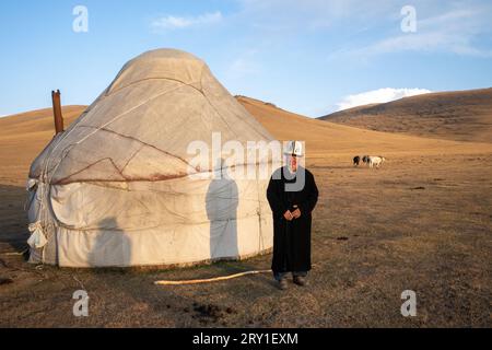 Kyrgyz uomo in abito tradizionale vicino alla sua yurta kyrgyzstan Foto Stock