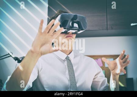 Trader Man che guarda in ufficio con occhiali VR. Realtà virtuale e concetto tecnologico Foto Stock