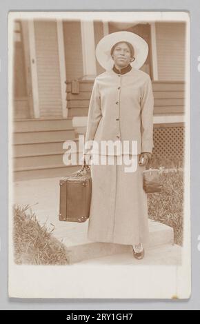 Cartolina fotografica di una donna non identificata con una borsa da viaggio 1904-1918 Foto Stock