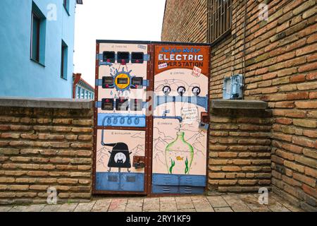 Due scatole elettriche con una divertente scena di esperimenti scientifici. Una delle tante opere pubbliche di Street art e graffiti di Gosha, Goshaart. A Tbilisi, Foto Stock