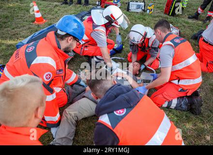 28 settembre 2023, Sassonia, Wiederau: I paramedici di emergenza in erba trattano un uomo che rappresenta una persona lesa durante un'esercitazione terroristica. Circa 150 tirocinanti della Croce Rossa tedesca, dei samaritani e dell'ambulanza di San Giovanni della Sassonia e della Sassonia-Anhalt prendono parte a una situazione terroristica messa in scena alla fine di una settimana di addestramento. C'è stato un assassinio con numerose vittime: L'autore si è trincerato, sono sparati colpi, c'è fumo, la polizia pesantemente armata e incappucciata attacca l'edificio. Successivamente, i paramedici di emergenza devono curare i feriti. Foto: Jan Woitas/dpa Credit: dpa pictur Foto Stock