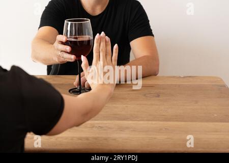 Donna potenziata che rifiuta l'alcol: NOLO, astinenza, affrontare problemi di alcol, dire di no alle bevande alle riunioni sociali, stile di vita senza sostanze Foto Stock