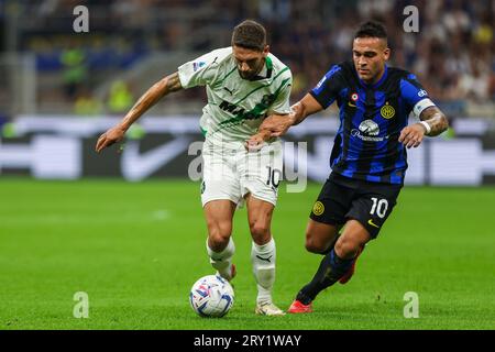 Domenico Berardi dell'US Sassuolo (L) compete per la palla con Lautaro Martinez dell'FC Internazionale (R) durante la partita di serie A 2023/24 tra FC Internazionale e US Sassuolo allo Stadio Giuseppe Meazza. PUNTEGGIO FINALE : Inter 1 | 2 Sassuolo Foto Stock