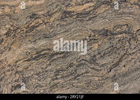 Struttura in granito con linee ondulate e piccole interruzioni di linea. Motivo sfondo pietra naturale con sfumatura marrone. sono necessari punti chiari e scuri nella pietra Foto Stock