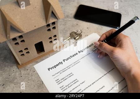 Acquisto immobiliare: Contratto di proprietà, prima casa, sogno proprietà, Casa famiglia, firma documenti immobiliari, chiavi per una casa moderna, smartphone Foto Stock