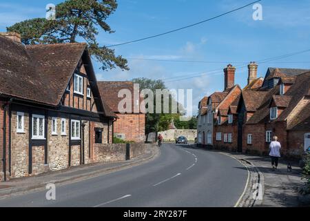 Villaggio Beaulieu nella New Forest, Hampshire, Inghilterra, Regno Unito - vista sulla strada con Beaulieu Mill sulla destra e ciclisti Foto Stock