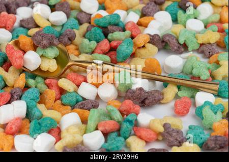 Cucchiaio dorato con vista ravvicinata macro di cornflakes colorati Foto Stock