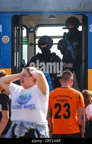 28 settembre 2023, Sassonia, Wiederau: Gli agenti di polizia proteggono un tram durante un'esercitazione terroristica. Circa 150 tirocinanti della Croce Rossa tedesca, dei samaritani e del Johanniter della Sassonia e della Sassonia-Anhalt prendono parte a una situazione terroristica messa in scena alla fine di una settimana di addestramento. C'è stato un attacco con numerose vittime: L'autore si è trincerato, sono sparati colpi, c'è fumo, la polizia pesantemente armata e incappucciata attacca l'edificio. Successivamente, i paramedici di emergenza devono curare i feriti. Foto: Jan Woitas/dpa Foto Stock