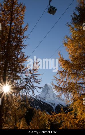 Maestoso paesaggio di montagne rocciose con alberi di conifere contro il cielo blu al tramonto in svizzera in autunno Foto Stock