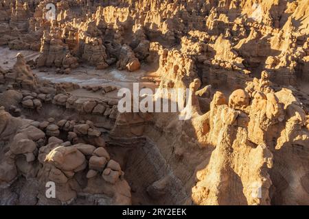 Pittoresca vista con droni di insoliti pinnacoli di roccia a forma di fungo sotto il cielo blu senza nuvole nel Goblin Valley State Park nelle giornate di sole Foto Stock