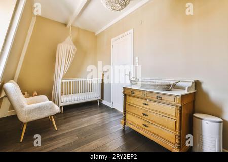 Lettino e moderna sedia grigia e pianta interna nella camera da letto per  bambini Foto stock - Alamy