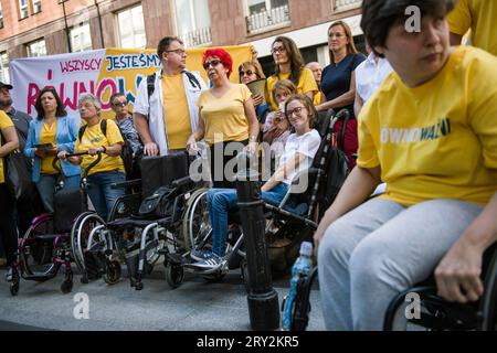 Varsavia, Polonia - 28 settembre 2023 le persone con disabilità e i loro operatori assistono alla marcia "siamo tutti UGUALMENTE IMPORTANTI". Una marcia organizzata dal partito politico polacco 2050 (Polska 2050) con lo slogan "siamo tutti UGUALMENTE IMPORTANTI" (Wszyscy Jestemy ROWNOWAZNI) guidato da Lukasz Krason, passava per le strade di Varsavia. I partecipanti indossavano magliette gialle (colore della festa); alcuni di loro hanno spinto passeggini vuoti per simboleggiare le persone che potrebbero avere disabilità in futuro. Le persone con disabilità vogliono un sistema che dia una mano nei momenti difficili. Questo è ciò che questa marcia è abo Foto Stock