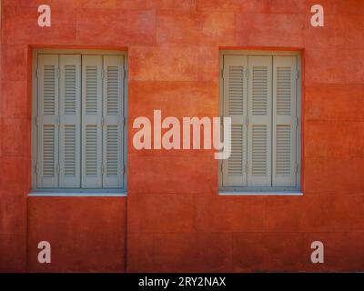 Graziosi dettagli di finestre, porte e balconi di una vecchia casa sull'isola di Simi. Vacanze nelle isole della Grecia da Rodi nel Mar Egeo. Case colorate in stile neoclassico nella baia di Symi. Informazioni generali sui viaggi di vacanza. Foto Stock