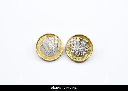 Una moneta da un euro e una moneta britannica da una sterlina isolata su un semplice sfondo bianco. Copia spazio. Foto Stock