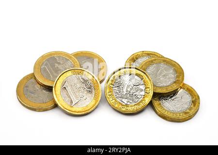 Monete da un euro e monete da una sterlina britanniche isolate su un semplice sfondo bianco. Copia spazio. Foto Stock