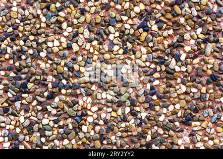 Consistenza di pietre di ceramica marrone. Sfondo marrone dorso di una facciata. Superficie in ceramica. Consistenza di piccole ciottoli scuri colorati. Pavimento in mosaico, co Foto Stock