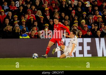 Cardiff, Galles - 28 marzo 2023: Il gallese Connor Roberts viene affrontato dal lettone Raivis Jurkovskis durante il girone D del Campionato europeo di calcio Qualifyi Foto Stock