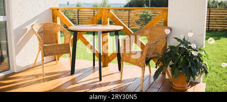 Banner accogliente terrazza in legno di casa di campagna o cottage con vista giardino - tavolo e sedia per una serata rilassante Foto Stock