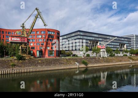 Duisburg, Ruhrgebiet, Nordrhein-Westfalen, Deutschland - Innenhafen Duisburg mit dem wellenfoermigen Gebaeude vom Landesarchiv Nordrhein-Westfalen und alten Hafenkraenen. Rechts moderne Buerogebaeude. Duisburg Nordrhein-Westfalen Deutschland *** Duisburg, Ruhr area, Renania settentrionale Vestfalia, Germania Duisburg Inner Harbor con l'edificio a forma d'onda dell'Archivio di Stato della Renania settentrionale-Vestfalia e vecchie gru portuali a destra moderni edifici per uffici di Duisburg Renania settentrionale-Vestfalia Germania Foto Stock