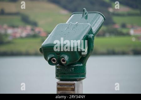 GRUYERE, SVIZZERA - 6 AGOSTO 2023: Telescopio al Motel de la Gruyere con il lago Gruyere sullo sfondo Foto Stock