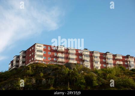 Edificio residenziale rosso con cooperativa abitativa svedese e unità in affitto con locatari a Nacka, Svezia, per concetto immobiliare commerciale Foto Stock