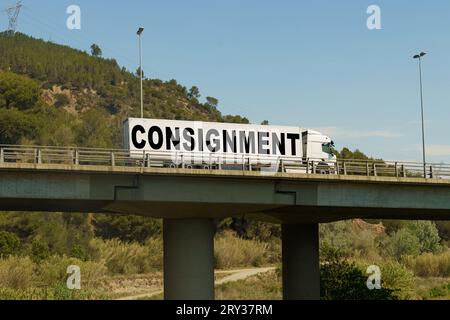 Un veicolo sta attraversando il ponte, con l'iscrizione sul rimorchio - spedizione. Concetto di logistica. Foto Stock