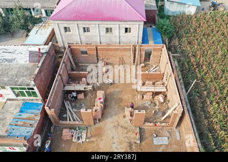 Baoding. 26 settembre 2023. Questa foto aerea scattata il 26 settembre 2023 mostra i lavoratori che ricostruiscono un edificio danneggiato nella città di Diaowo, nella città di Zhuozhou, nella provincia di Hebei nella Cina settentrionale. I lavori di ripristino e ricostruzione post-catastrofe vengono effettuati nelle aree dell'Hebei che sono state devastate dalle inondazioni in agosto. Crediti: MU Yu/Xinhua/Alamy Live News Foto Stock