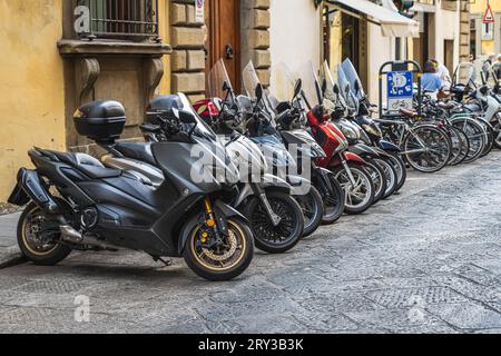 Firenze, Italia — 13 settembre 2023. Un'immagine orizzontale di un sacco di motociclette allineate e parcheggiate lungo una strada laterale a Firenze, Italia. Foto Stock