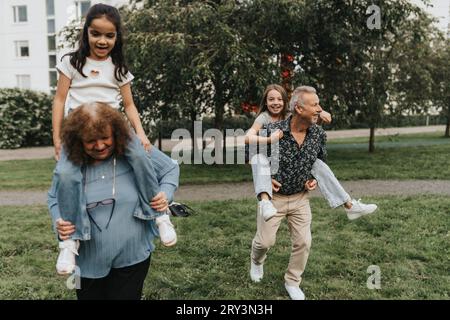 Nonni e nipoti giocosi al parco Foto Stock