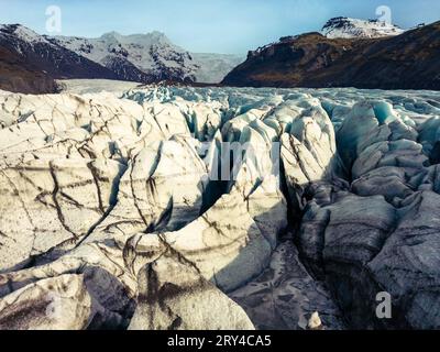 Shot con drone di blocchi di ghiaccio vatnajokull che galleggiano sul lago nordico, creando un maestoso paesaggio della laguna del ghiacciaio polare. Spettacolare paesaggio islandese con enormi iceberg blu con grotte. Foto Stock