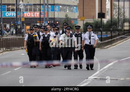 La polizia metropolitana, compresi i primi soccorritori sulla scena del letale accoltellamento, giaceva dei fiori dove Elianne Andam, un'allieva della scuola privata Old Palace di John Whitgift, è stata aggredita e uccisa alle 8:30 di ieri mentre scendeva dall'autobus a Croydon, South London, Croydon, Londra, Regno Unito 28 settembre 2023 crediti: Jeff Gilbert/Alamy Live News Foto Stock