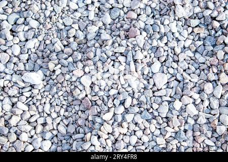 Sfondi rotondi lisci. Spiaggia di ciottoli in primo piano, ciottoli umidi e ghiaia secca grigia. Foto Stock